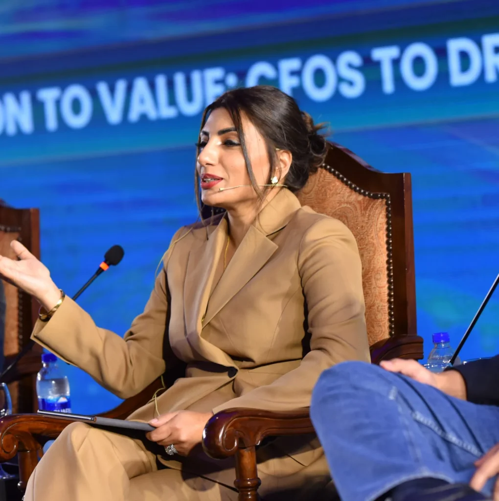 A professional woman delivering insights as a keynote speaker during a business panel discussion.